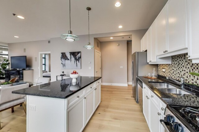 101 W Superior St Unit 501, Chicago, IL 60654 - kitchen with a sink, open floor plan, a kitchen island, white cabinetry, and backsplash