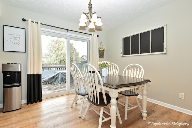 155 Shadowbrook Dr, Capron, IL 61012 - dining area with a chandelier, light wood-type flooring, a textured ceiling, and baseboards