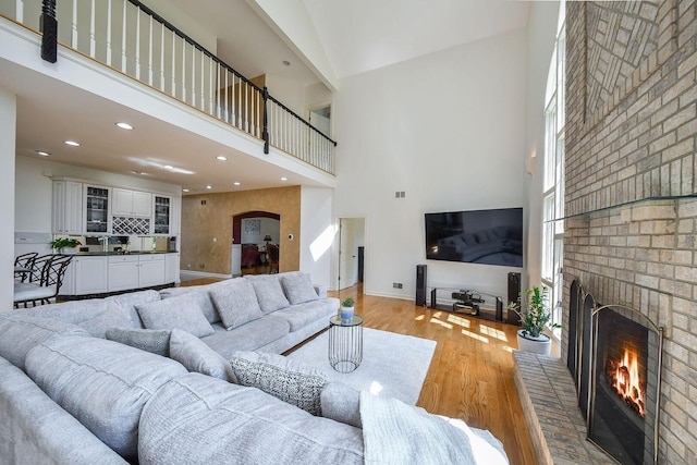 5N311 Lloyd Ave, Itasca, IL 60143 - living room with a high ceiling, a fireplace, arched walkways, light wood-style flooring, and recessed lighting