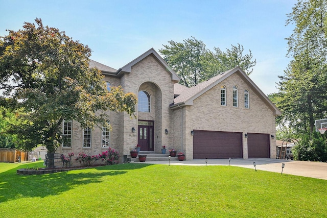 5N311 Lloyd Ave, Itasca, IL 60143 - traditional-style home featuring an attached garage, a front lawn, brick siding, and driveway