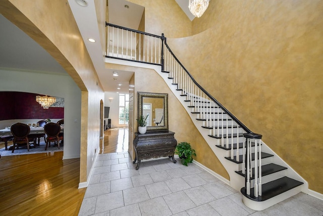 5N311 Lloyd Ave, Itasca, IL 60143 - staircase with a chandelier, arched walkways, a high ceiling, tile patterned flooring, and recessed lighting