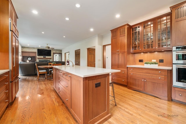 1602 Wickham Ct, Libertyville, IL 60048 - kitchen featuring double oven, a breakfast bar area, a ceiling fan, light wood finished floors, and recessed lighting