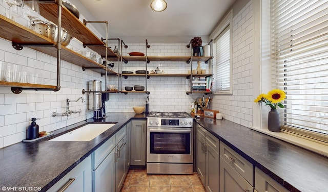 5842 N Wayne Ave Unit 1, Chicago, IL 60660 - kitchen featuring open shelves, gas stove, decorative backsplash, dark countertops, and a sink