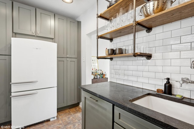 5842 N Wayne Ave Unit 1, Chicago, IL 60660 - kitchen with freestanding refrigerator, open shelves, gray cabinetry, and backsplash