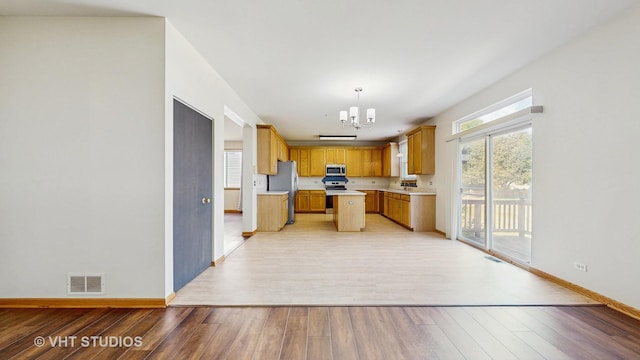 6542 Pine Hollow Rd, Carpentersville, IL 60110 - kitchen with appliances with stainless steel finishes, a chandelier, light wood-style flooring, light countertops, and pendant lighting