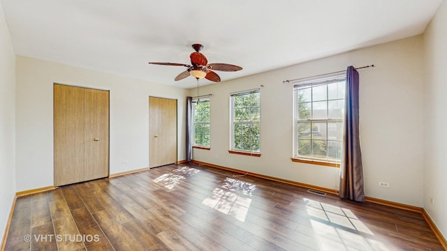 6542 Pine Hollow Rd, Carpentersville, IL 60110 - unfurnished bedroom with two closets, wood finished floors, and a ceiling fan