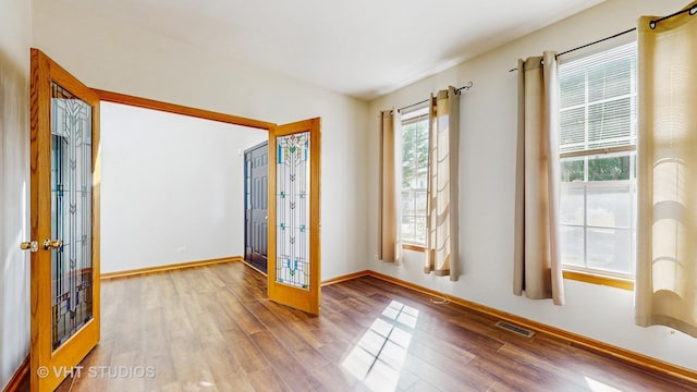 6542 Pine Hollow Rd, Carpentersville, IL 60110 - unfurnished room featuring plenty of natural light, wood finished floors, and french doors