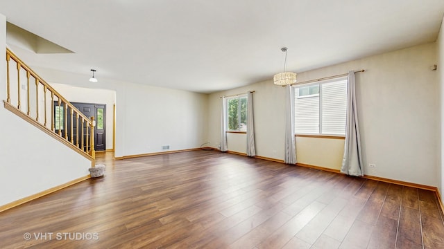 6542 Pine Hollow Rd, Carpentersville, IL 60110 - spare room with stairway, wood finished floors, and a chandelier