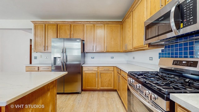 6542 Pine Hollow Rd, Carpentersville, IL 60110 - kitchen with stainless steel appliances, light countertops, light wood-style flooring, and backsplash