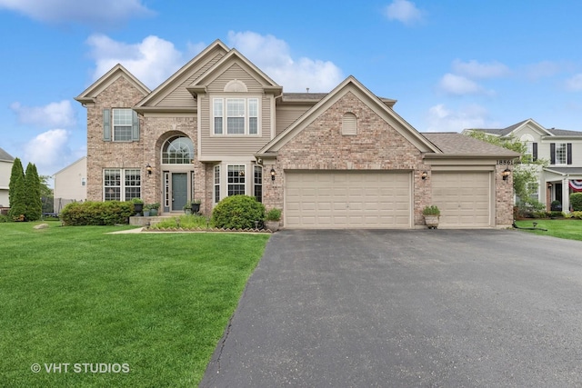 18861 W Aspen Ct, Lake Villa, IL 60046 - traditional-style home with a front lawn, an attached garage, asphalt driveway, and brick siding