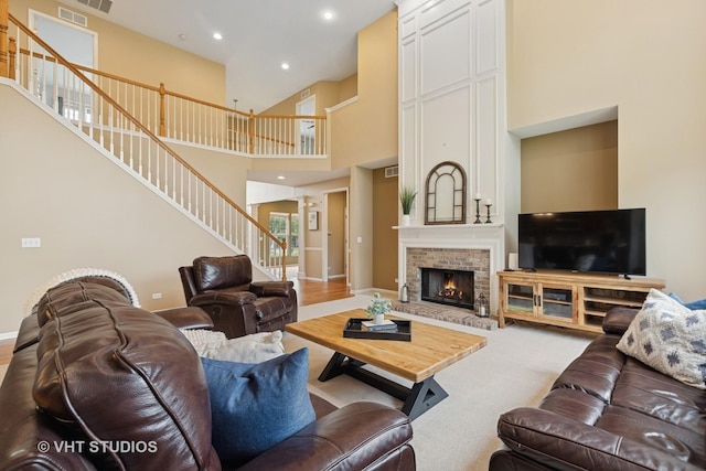 18861 W Aspen Ct, Lake Villa, IL 60046 - carpeted living area featuring stairs, a towering ceiling, a fireplace, and recessed lighting