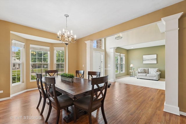 18861 W Aspen Ct, Lake Villa, IL 60046 - dining room with decorative columns, wood-type flooring, and a chandelier