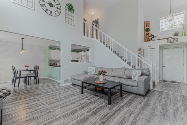 2367 Camden Bay, Elgin, IL 60123 - living area featuring high vaulted ceiling, stairs, light wood-style floors, baseboards, and brick wall