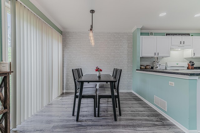 2367 Camden Bay, Elgin, IL 60123 - dining space with crown molding, wood finished floors, brick wall, and baseboards