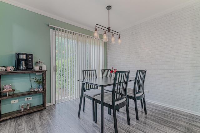 2367 Camden Bay, Elgin, IL 60123 - dining area featuring brick wall, wood finished floors, a chandelier, baseboards, and crown molding