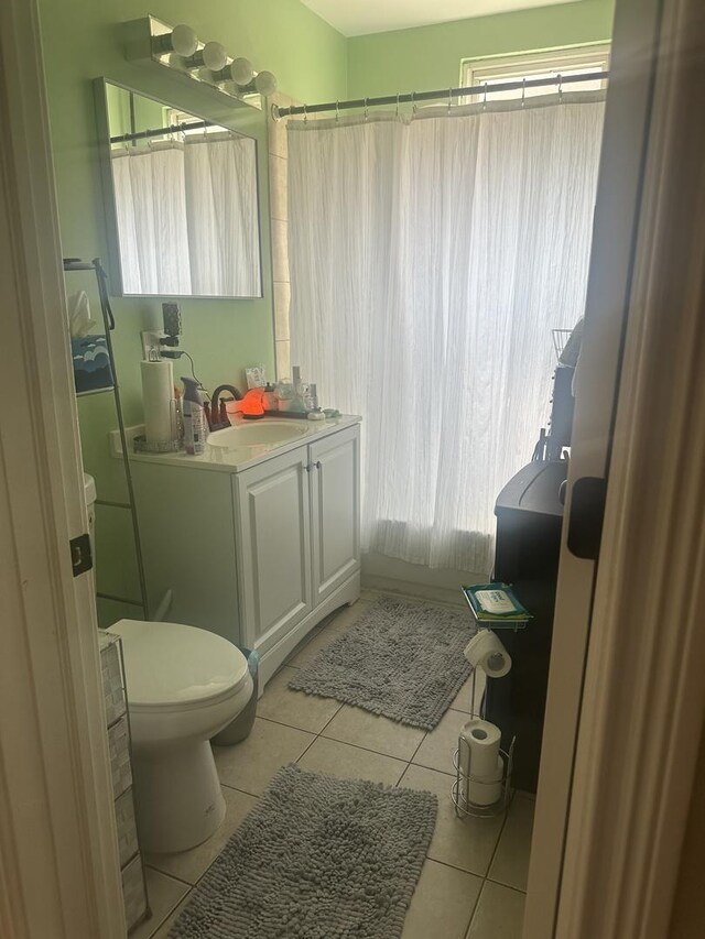 7127 S Eberhart Ave, Chicago, IL 60619 - full bath featuring tile patterned flooring, vanity, toilet, and plenty of natural light
