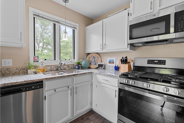 972 W Ct Unit C, Naperville, IL 60563 - kitchen with stainless steel appliances, a sink, white cabinetry, light stone counters, and decorative light fixtures