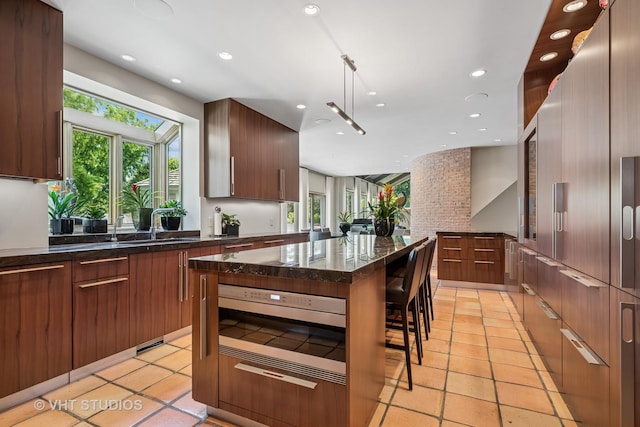 1242 Antietam Dr, Long Grove, IL 60047 - kitchen featuring modern cabinets, stainless steel microwave, dark stone countertops, recessed lighting, and light tile patterned flooring