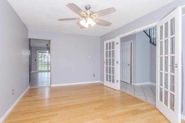 102 Merganser Ct, Downs, IL 61736 - unfurnished room with french doors, light wood finished floors, ceiling fan, and baseboards