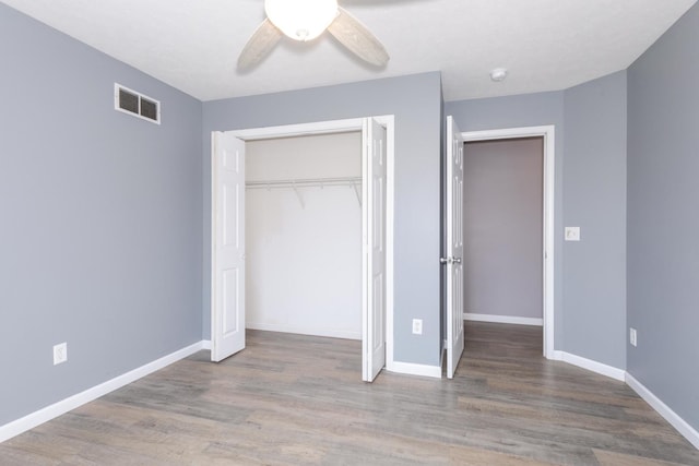 102 Merganser Ct, Downs, IL 61736 - unfurnished bedroom with wood finished floors, a closet, baseboards, and a ceiling fan