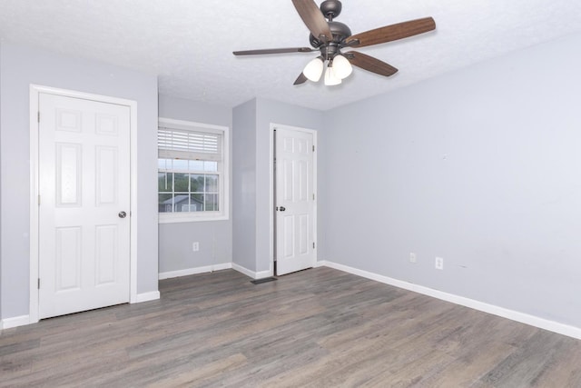 102 Merganser Ct, Downs, IL 61736 - unfurnished bedroom featuring wood finished floors, baseboards, and a ceiling fan