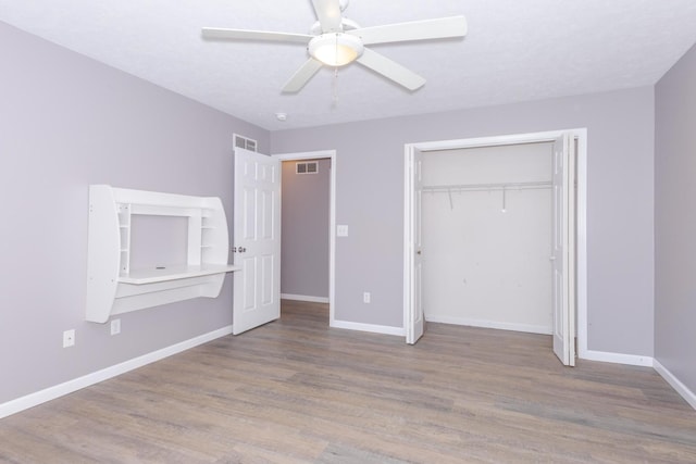 102 Merganser Ct, Downs, IL 61736 - unfurnished bedroom with wood finished floors, baseboards, a closet, and ceiling fan