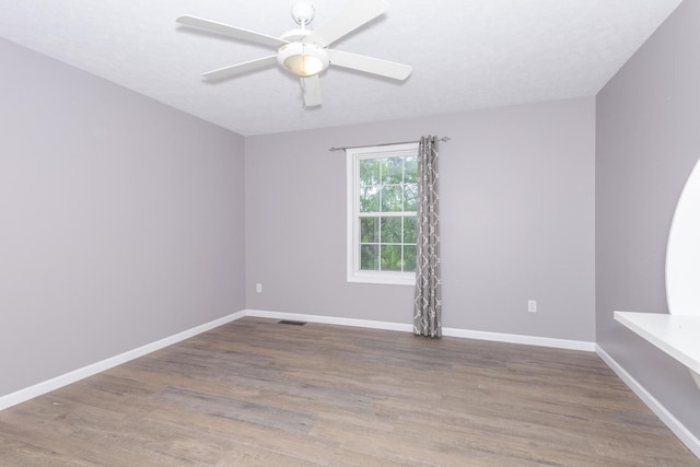 102 Merganser Ct, Downs, IL 61736 - empty room featuring wood finished floors, a ceiling fan, and baseboards
