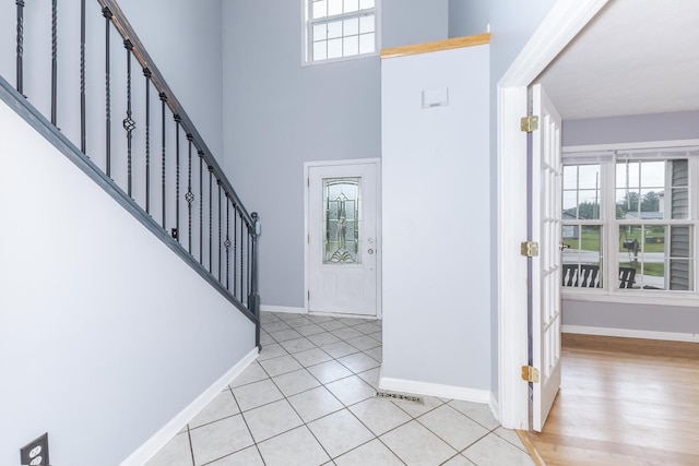 102 Merganser Ct, Downs, IL 61736 - entryway featuring healthy amount of natural light, stairway, baseboards, a towering ceiling, and light tile patterned floors