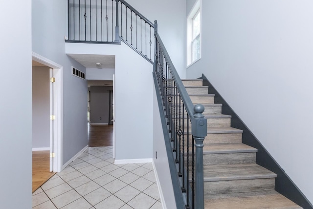 102 Merganser Ct, Downs, IL 61736 - staircase with a high ceiling, tile patterned floors, and baseboards