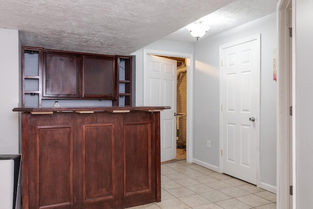 102 Merganser Ct, Downs, IL 61736 - bar featuring a textured ceiling, light tile patterned floors, and baseboards
