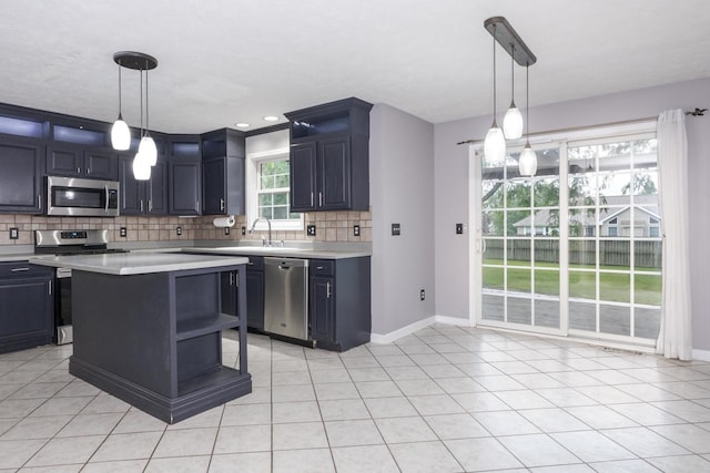 102 Merganser Ct, Downs, IL 61736 - kitchen featuring stainless steel appliances, light countertops, decorative backsplash, a sink, and baseboards