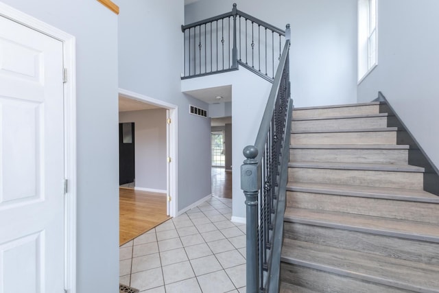 102 Merganser Ct, Downs, IL 61736 - stairway featuring tile patterned flooring, baseboards, and a high ceiling