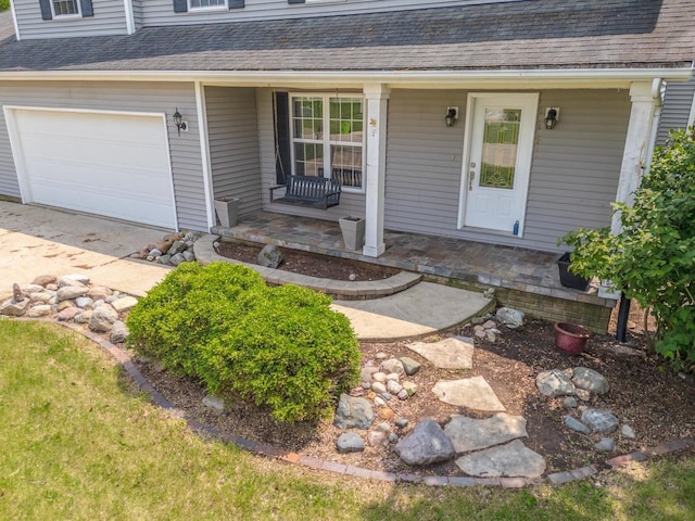 102 Merganser Ct, Downs, IL 61736 - view of exterior entry featuring covered porch, a shingled roof, and an attached garage