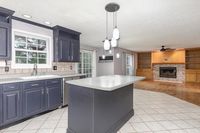 102 Merganser Ct, Downs, IL 61736 - kitchen featuring a sink, stainless steel dishwasher, a ceiling fan, a stone fireplace, and light countertops