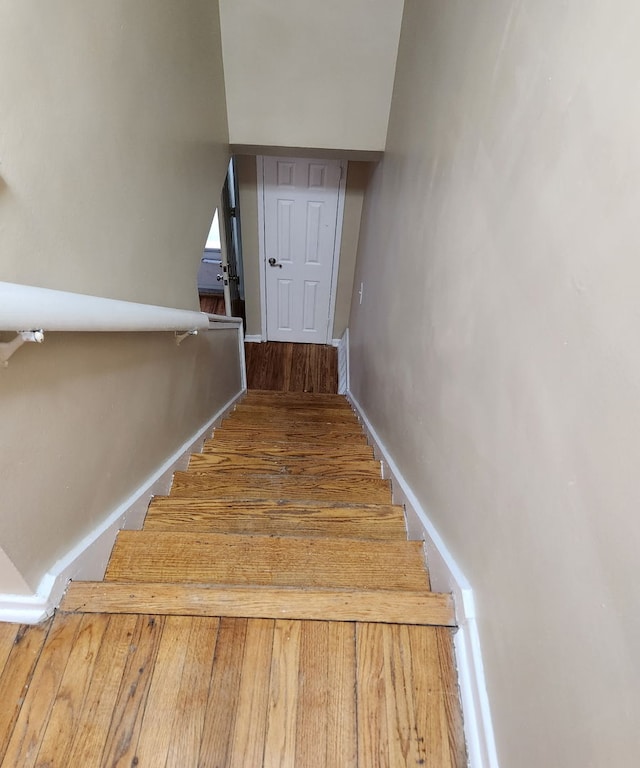 stairway featuring wood finished floors and baseboards
