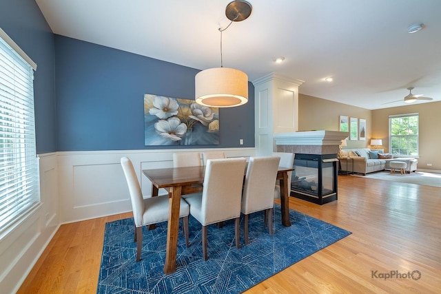 155 Willow Blvd, Willow Springs, IL 60480 - dining space featuring wood finished floors, a fireplace, a ceiling fan, and wainscoting