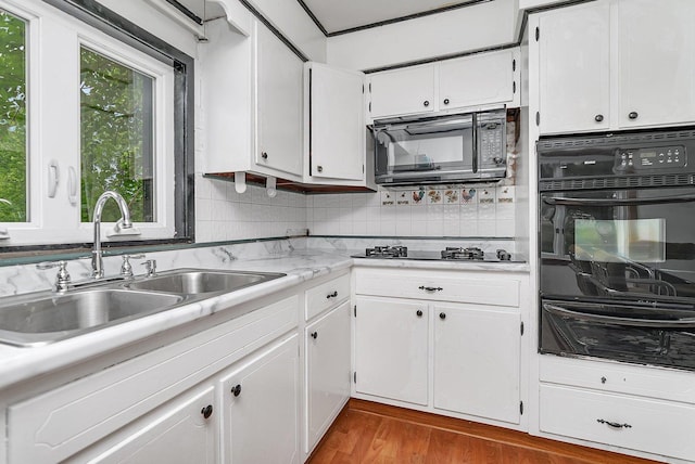 302 Wabash Ave, Campus, IL 60920 - kitchen featuring black appliances, a warming drawer, a sink, light countertops, and white cabinetry