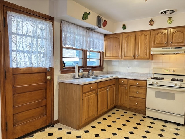 2825 N Indian Boundary Rd, River Grove, IL 60171 - kitchen featuring under cabinet range hood, white gas range oven, brown cabinets, and light countertops