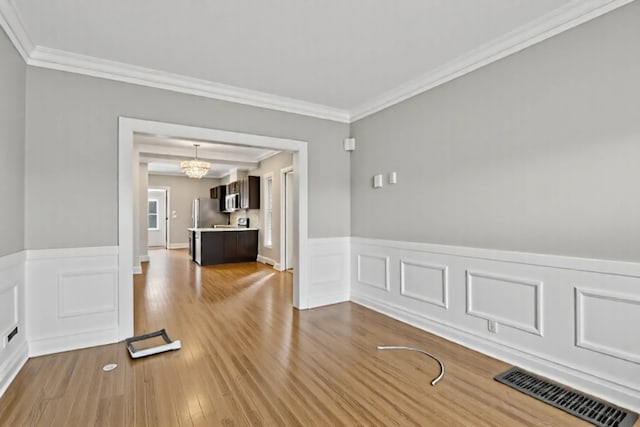 3731 Maple Ave, Berwyn, IL 60402 - spare room with wainscoting, crown molding, wood finished floors, and a chandelier