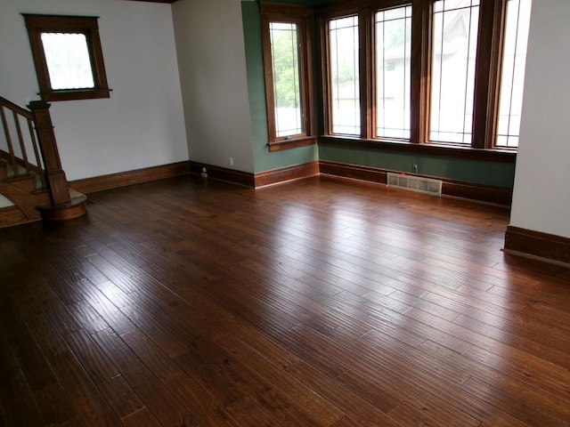 1023 Rock St, Peru, IL 61354 - spare room featuring plenty of natural light, stairway, baseboards, and dark wood-style flooring
