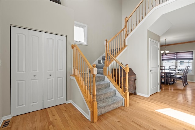 1809 Pembrook Ct, Plainfield, IL 60586 - stairway featuring wood finished floors, baseboards, a chandelier, and a high ceiling