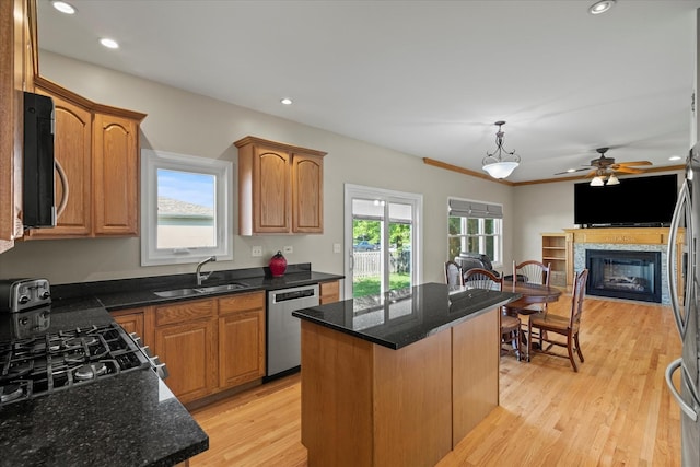 1809 Pembrook Ct, Plainfield, IL 60586 - kitchen featuring stainless steel appliances, a sink, a kitchen island, a glass covered fireplace, and ceiling fan