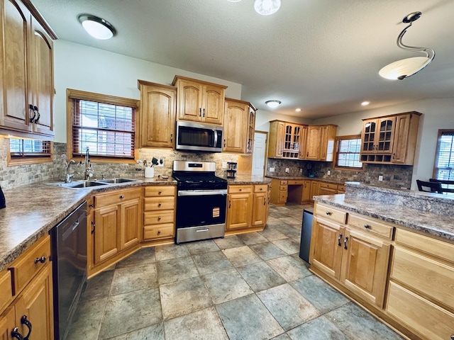 1102 Brian Dr, Manteno, IL 60950 - kitchen featuring stainless steel appliances, a sink, glass insert cabinets, decorative backsplash, and brown cabinetry