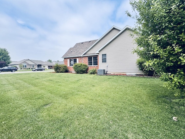 1102 Brian Dr, Manteno, IL 60950 - view of side of home featuring a yard, central AC unit, and brick siding