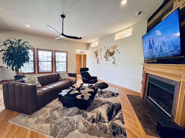 1102 Brian Dr, Manteno, IL 60950 - living area with wood finished floors, a fireplace with flush hearth, ceiling fan, a textured ceiling, and baseboards