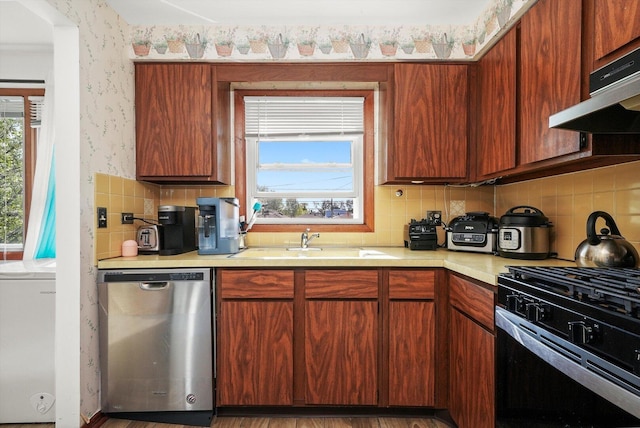6568 W Roscoe St Unit 2N, Chicago, IL 60634 - kitchen with dishwasher, black range with gas cooktop, under cabinet range hood, light countertops, and backsplash