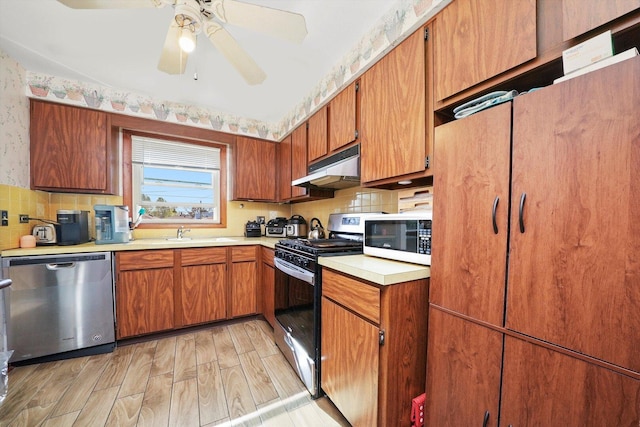 6568 W Roscoe St Unit 2N, Chicago, IL 60634 - kitchen featuring appliances with stainless steel finishes, under cabinet range hood, light countertops, tasteful backsplash, and ceiling fan