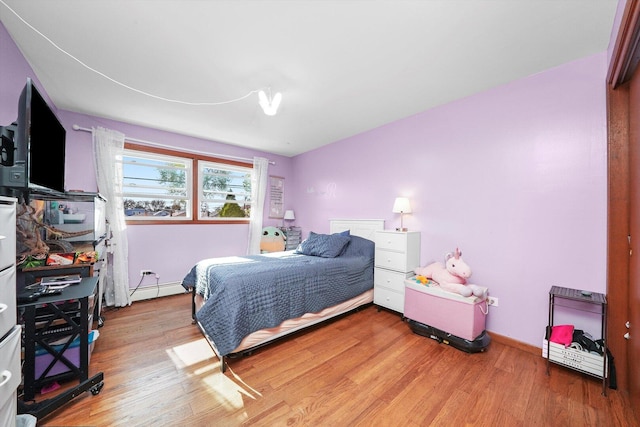 6568 W Roscoe St Unit 2N, Chicago, IL 60634 - bedroom with light wood-type flooring, a baseboard heating unit, and baseboards