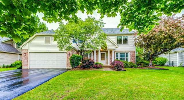 713 Warwick Ln, Lake Zurich, IL 60047 - view of front facade with driveway, brick siding, an attached garage, and a front lawn