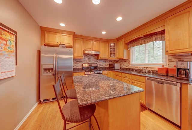 713 Warwick Ln, Lake Zurich, IL 60047 - kitchen featuring stainless steel appliances, under cabinet range hood, a sink, backsplash, and a breakfast bar
